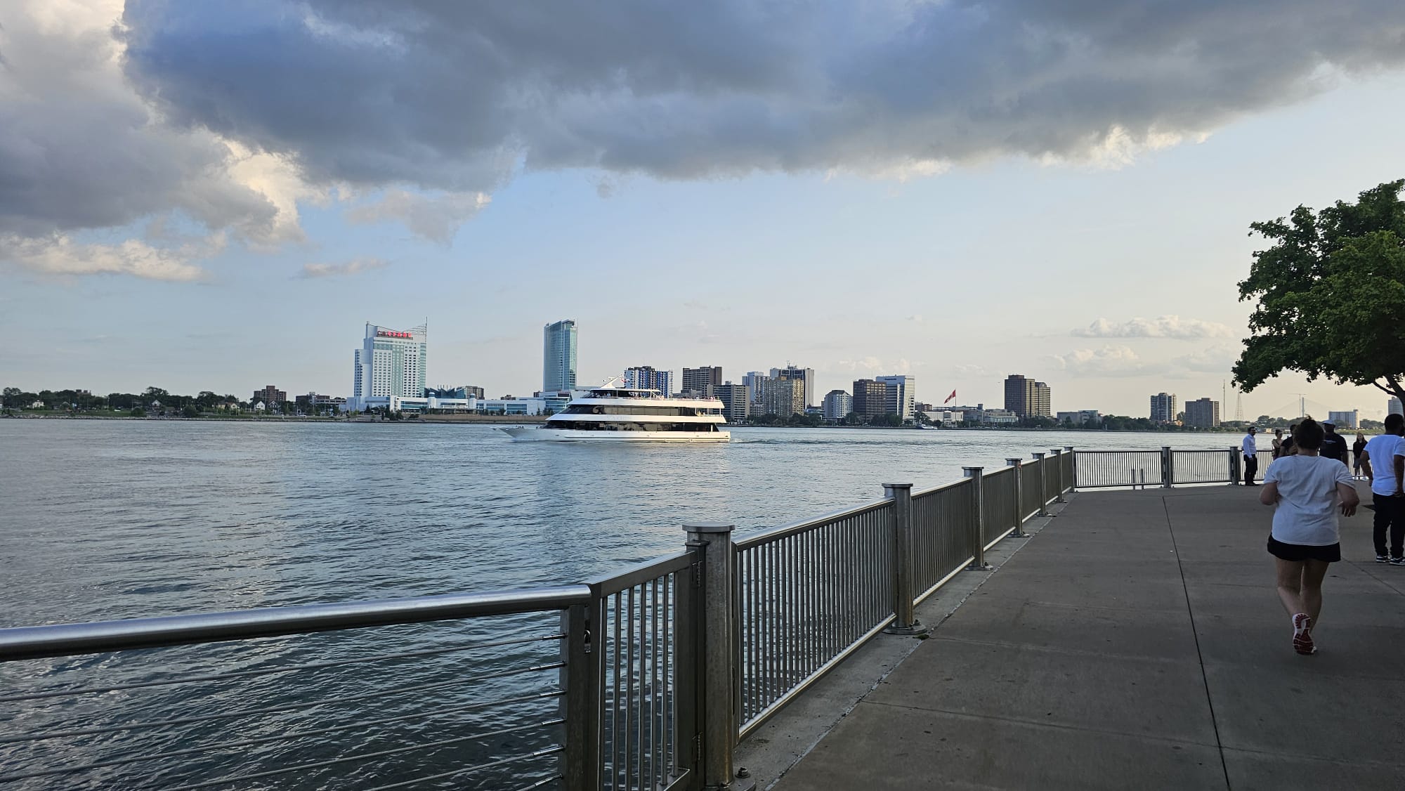 Pedestrians walking along the Detroit Riverwalk with views of the river
